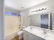 Bright bathroom featuring a double vanity, shower-tub combo, and modern lighting at 1595 S 227Th Ave, Buckeye, AZ 85326