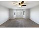 Large empty bedroom with a ceiling fan, bay window, and neutral carpet at 1595 S 227Th Ave, Buckeye, AZ 85326