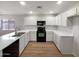 Modern kitchen with white cabinets, quartz countertops, and stainless steel appliances at 1595 S 227Th Ave, Buckeye, AZ 85326