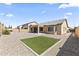 A backyard with a covered patio, gravel, and a square patch of grass at 16762 W Sonora St, Goodyear, AZ 85338