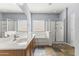 Bright bathroom featuring double sinks, a soaking tub, and a glass-enclosed shower, creating a spa-like experience at 16762 W Sonora St, Goodyear, AZ 85338