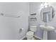 Powder room with pedestal sink, toilet, and chrome accessories at 16762 W Sonora St, Goodyear, AZ 85338