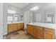 Well-lit bathroom with double sinks, white countertops, and wooden cabinets, enhancing its bright, modern feel at 16762 W Sonora St, Goodyear, AZ 85338