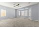 Large bedroom with neutral carpet and many bright windows providing natural light at 16762 W Sonora St, Goodyear, AZ 85338