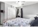 Bright bedroom featuring a ceiling fan, sliding door closet, and a patterned comforter at 16821 S 23Rd St, Phoenix, AZ 85048