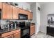 Modern kitchen with wood cabinets, black appliances, and light walls at 16821 S 23Rd St, Phoenix, AZ 85048