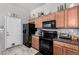 Kitchen with wood cabinets, dark countertops, and appliances at 16821 S 23Rd St, Phoenix, AZ 85048