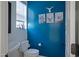 Stylish bathroom with a bold blue wall, decorative artwork, and modern fixtures at 1694 E Dogwood Ln, Gilbert, AZ 85295