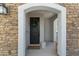 Inviting front entrance with a stone archway and a stylish black door adorned with a decorative wreath at 1694 E Dogwood Ln, Gilbert, AZ 85295