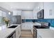 Spacious kitchen with white cabinets, quartz countertops, stainless steel appliances, and blue backsplash at 1694 E Dogwood Ln, Gilbert, AZ 85295