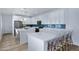 Modern kitchen with white cabinets, stainless steel appliances, blue subway tile backsplash, and bar seating at 1694 E Dogwood Ln, Gilbert, AZ 85295