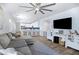 Open-concept living area flowing into a modern kitchen with white cabinetry and a large TV at 1694 E Dogwood Ln, Gilbert, AZ 85295