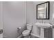 Half bath features a pedestal sink, toilet, and decorative mirror at 17118 N 50Th Way, Scottsdale, AZ 85254