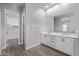 Bright bathroom featuring double sinks, white cabinets, and a door leading into a walk-in closet at 17118 N 50Th Way, Scottsdale, AZ 85254
