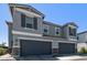 Close-up showcasing a charming two-story home with gray facade and dark garage doors at 17118 N 50Th Way, Scottsdale, AZ 85254