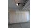 Garage featuring built-in, light-colored storage cabinets and overhead garage door opener at 17118 N 50Th Way, Scottsdale, AZ 85254