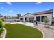 Beautiful backyard with synthetic grass, a spa, an outdoor kitchen, and travertine pavers at 1720 W Aloe Vera Dr, Phoenix, AZ 85085