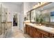 Bathroom with double sinks, granite counters, and a walk-in closet with lots of shelving for ample storage at 1720 W Aloe Vera Dr, Phoenix, AZ 85085