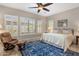 Serene bedroom with plush blue rug, natural light from the window, and a cozy seating area at 1720 W Aloe Vera Dr, Phoenix, AZ 85085