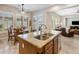 Gourmet kitchen island with granite countertop, stainless steel sink, and pendant lighting, open to dining and living area at 1720 W Aloe Vera Dr, Phoenix, AZ 85085