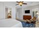 A carpetless main bedroom showcases a ceiling fan, accent chair and a TV above a wooden dresser at 1720 W Aloe Vera Dr, Phoenix, AZ 85085