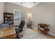Well-lit home office with a glass-top desk, shelving unit, and comfortable rolling chair at 1720 W Aloe Vera Dr, Phoenix, AZ 85085