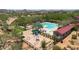 Aerial view of a community pool with lounge chairs, umbrellas, splash pad, and green spaces on a sunny day at 1720 W Aloe Vera Dr, Phoenix, AZ 85085