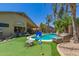 Lush backyard oasis featuring a sparkling pool, putting green, and shaded lounge area for outdoor enjoyment at 17796 W Andora St, Surprise, AZ 85388