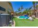 Expansive backyard with a pristine pool, mature landscaping, and a putting green for recreation at 17796 W Andora St, Surprise, AZ 85388