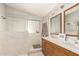 Bathroom featuring double sinks, wood cabinets, and a separate shower stall with bright natural light at 17796 W Andora St, Surprise, AZ 85388