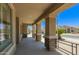 Inviting covered porch featuring stone pillars, neutral color scheme, and views of the well-maintained neighborhood at 17796 W Andora St, Surprise, AZ 85388