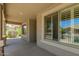 Inviting covered porch featuring stone pillars, neutral color scheme, and a relaxing view of the neighborhood at 17796 W Andora St, Surprise, AZ 85388