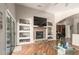 Bright living room with built-in shelves, stone fireplace, and wood floors creating a cozy and stylish living space at 17796 W Andora St, Surprise, AZ 85388