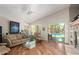 Bright living room features a vaulted ceiling, wood flooring, and large windows overlooking the backyard pool at 17796 W Andora St, Surprise, AZ 85388
