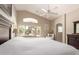 Bright bedroom with vaulted ceiling and a large window view of the landscaped backyard and water feature at 17796 W Andora St, Surprise, AZ 85388