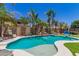 Beautiful backyard oasis with a sparkling pool, rock waterfall, and lush tropical landscaping at 17796 W Andora St, Surprise, AZ 85388