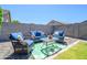 Cozy backyard patio features stylish outdoor seating around a glass table on a decorative green outdoor rug at 18027 W Tina Ln, Surprise, AZ 85387