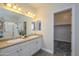 Bright bathroom with a double sink vanity, large mirror, and walk-in shower at 18027 W Tina Ln, Surprise, AZ 85387