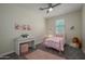 Bright bedroom with a pink bed, desk, and a comfortable, inviting atmosphere at 18027 W Tina Ln, Surprise, AZ 85387