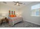 Cozy bedroom featuring a vibrant bedspread, decorative pillows, and a ceiling fan at 18027 W Tina Ln, Surprise, AZ 85387