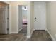 Bright entryway with wood-look tile flooring, a white front door, and bedroom view at 18027 W Tina Ln, Surprise, AZ 85387
