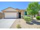 Charming home featuring a landscaped front yard, stone accents, and a two-car garage at 18027 W Tina Ln, Surprise, AZ 85387