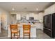 Bright kitchen with white cabinetry, stone countertops, stainless appliances, and tiled backsplash at 18027 W Tina Ln, Surprise, AZ 85387