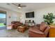 Bright living room offers comfortable seating, a large-screen TV, and views of the outdoor patio at 18027 W Tina Ln, Surprise, AZ 85387