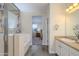 Well-lit main bathroom featuring a soaking tub with a shower, a vanity, and access to the main bedroom at 18027 W Tina Ln, Surprise, AZ 85387