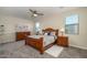Serene main bedroom features a wooden bed frame, soft carpeting, and natural light from multiple windows at 18027 W Tina Ln, Surprise, AZ 85387