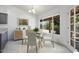 Bright dining area with a glass table, white chairs, and a view to the backyard at 19102 N 91St St, Scottsdale, AZ 85255
