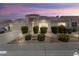 Charming single-story home with a well-manicured front yard and desert landscaping at sunset at 19102 N 91St St, Scottsdale, AZ 85255