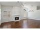 Spacious living room featuring a fireplace, hardwood floors, and natural light from large windows at 19102 N 91St St, Scottsdale, AZ 85255