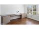 Office featuring a built-in desk with neutral cabinets and hardwood floors at 19102 N 91St St, Scottsdale, AZ 85255